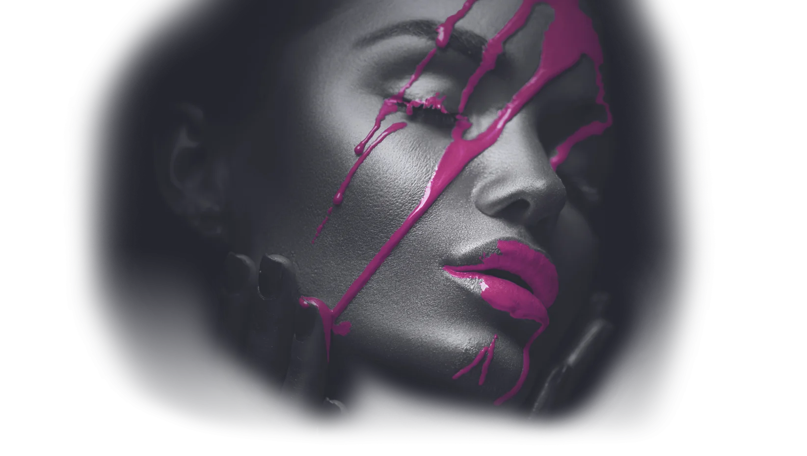 Das Gesicht einer Frau in Graustufen mit geschlossenen Augen, Lippen und Nägeln in leuchtendem Pink. Rosa Farbe ist dramatisch über ihr Gesicht gespritzt, was einen auffälligen visuellen Effekt erzeugt, der von der lebendigen Kunst Salzburgs inspiriert ist.
